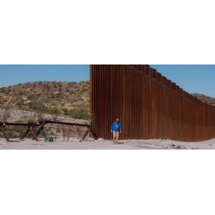 A volunteer with Humane Borders inspects an area east of Sasabe, Arizona, where the border wall ends and smaller barriers are set up to prevent people from crossing into the US. | United States 2023  Christopher Lee