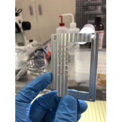 A researcher holds the scaffolding with tiny copper foils attached. These c  vl;opper pieces will be struck with lasers, heating them to thousands of degrees Fahrenheit.
Credit: Hiroshi Sawada