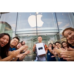 Team members cheer as the first customer leaves with his new purchase at Apple Wangfujing in Beijing.